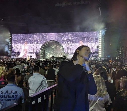 A woman near a concert audience and stage