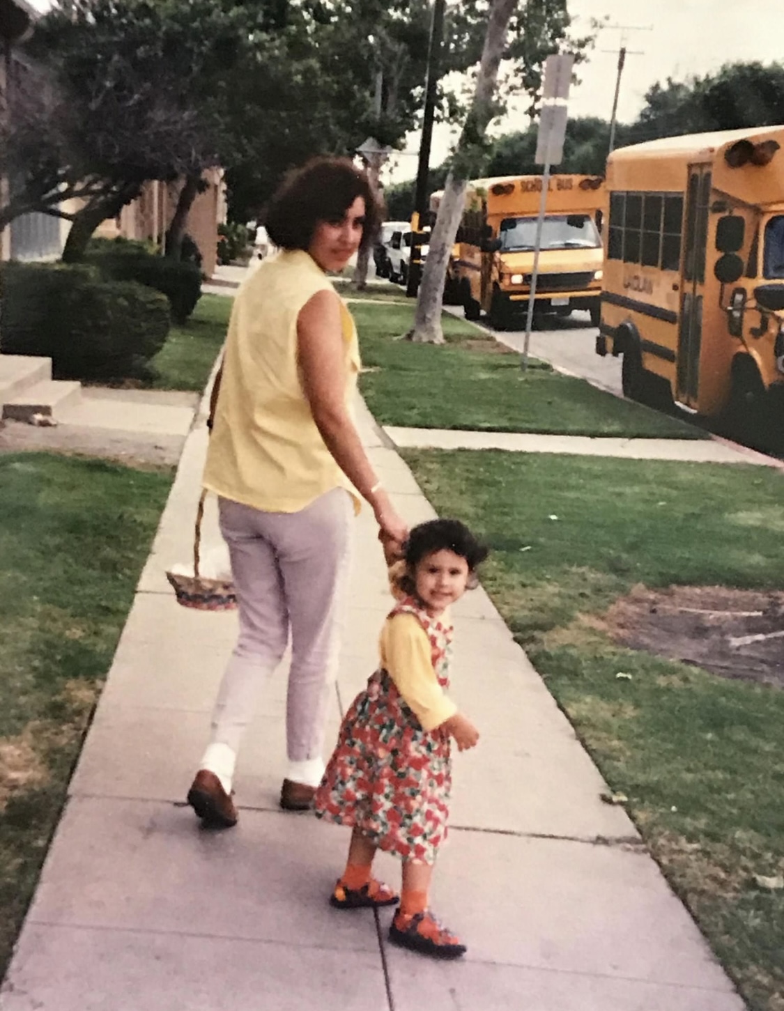 A woman and a young child walking together outdoors
